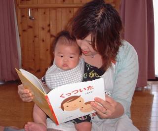 赤ちゃんに絵本を読む姿の写真