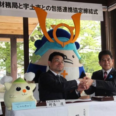 協定を締結し、がっちり握手する野島透九州財務局長(左)と元松市長の写真です